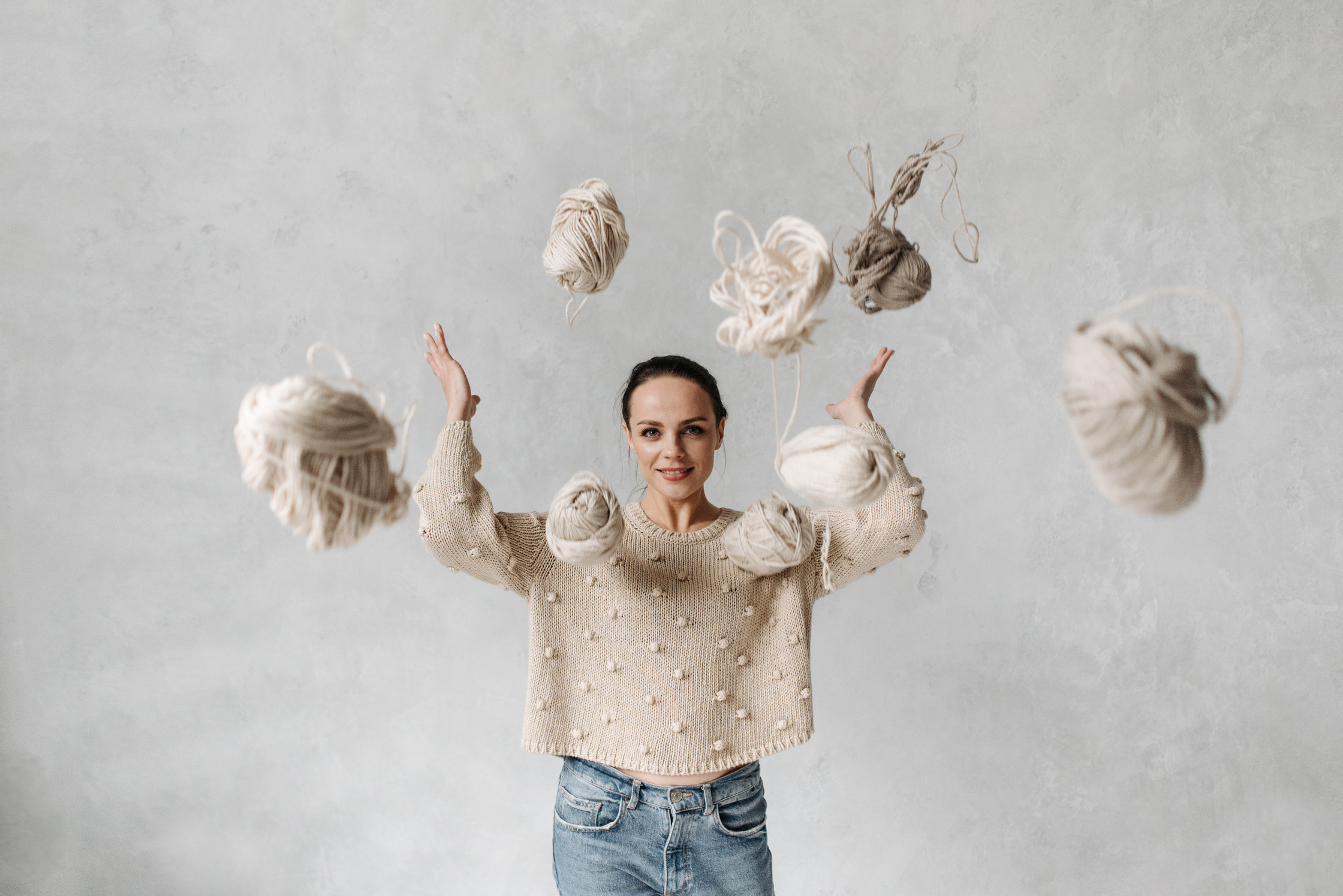 Girl in White Sweater Throwing Yarn Balls