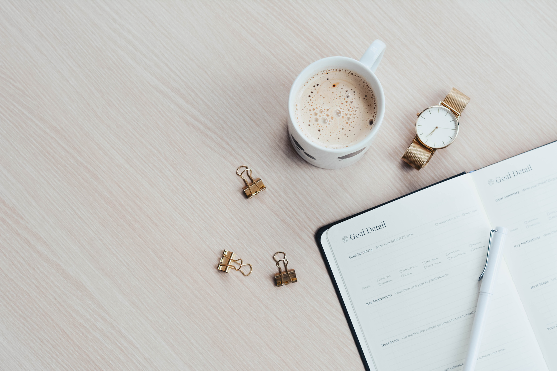 Mug, Watch, and Planner Book on Brown Wooden Surface